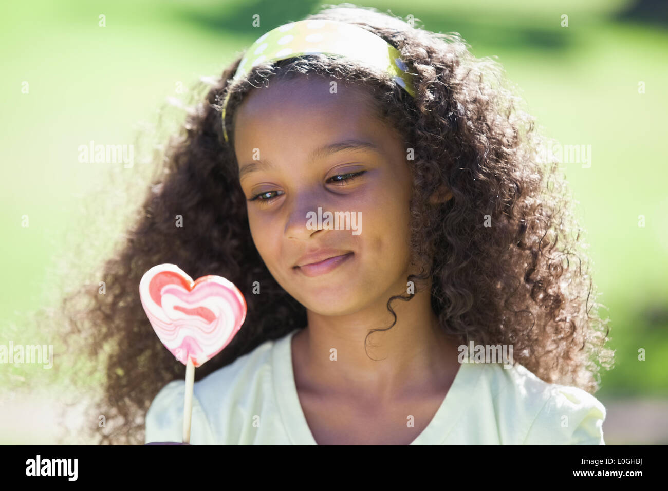 Young Girl holding a lollipop dans le parc Banque D'Images