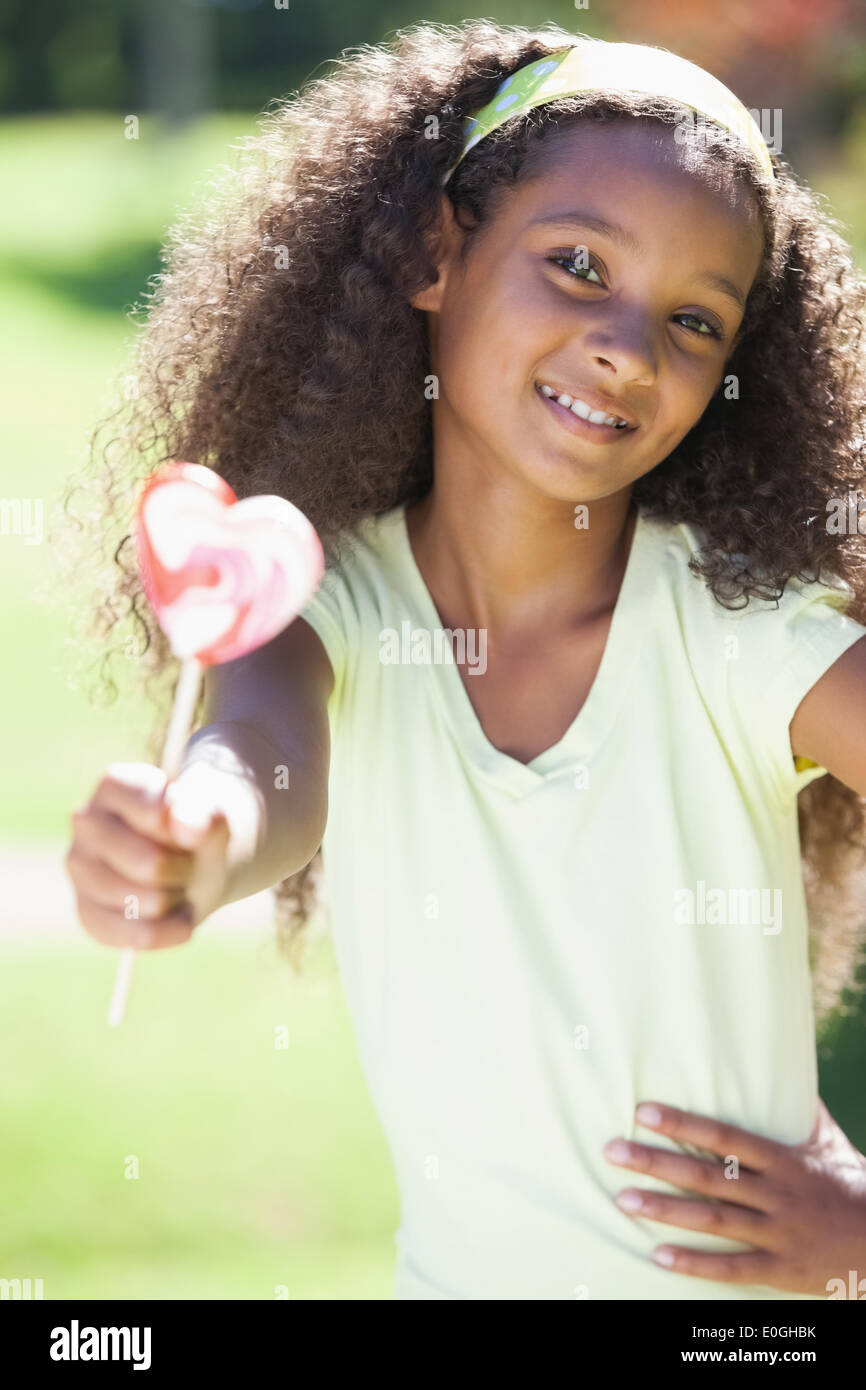 Young Girl holding a lollipop dans le parc Banque D'Images