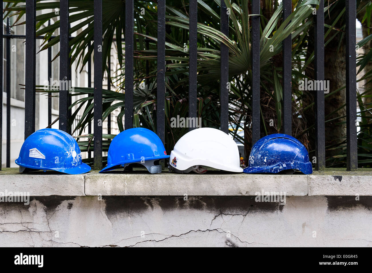 Quatre casques durs sur un mur. Banque D'Images