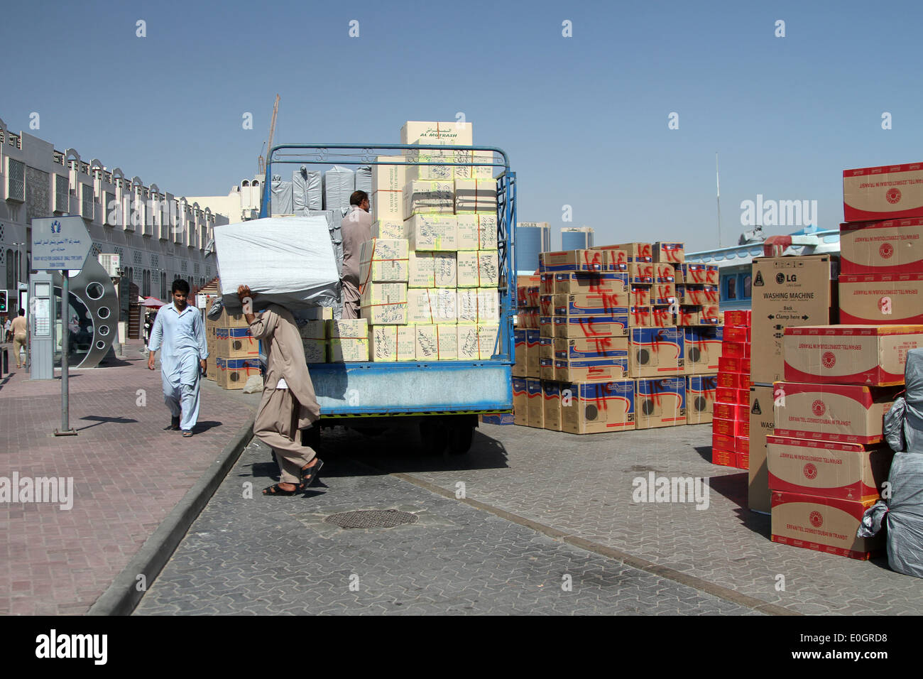 Décharger des marchandises les travailleurs à partir d'un van pour les transférer sur un bateau sur la Crique de Dubaï, qui sera ensuite les prendre à l'Iran. Banque D'Images