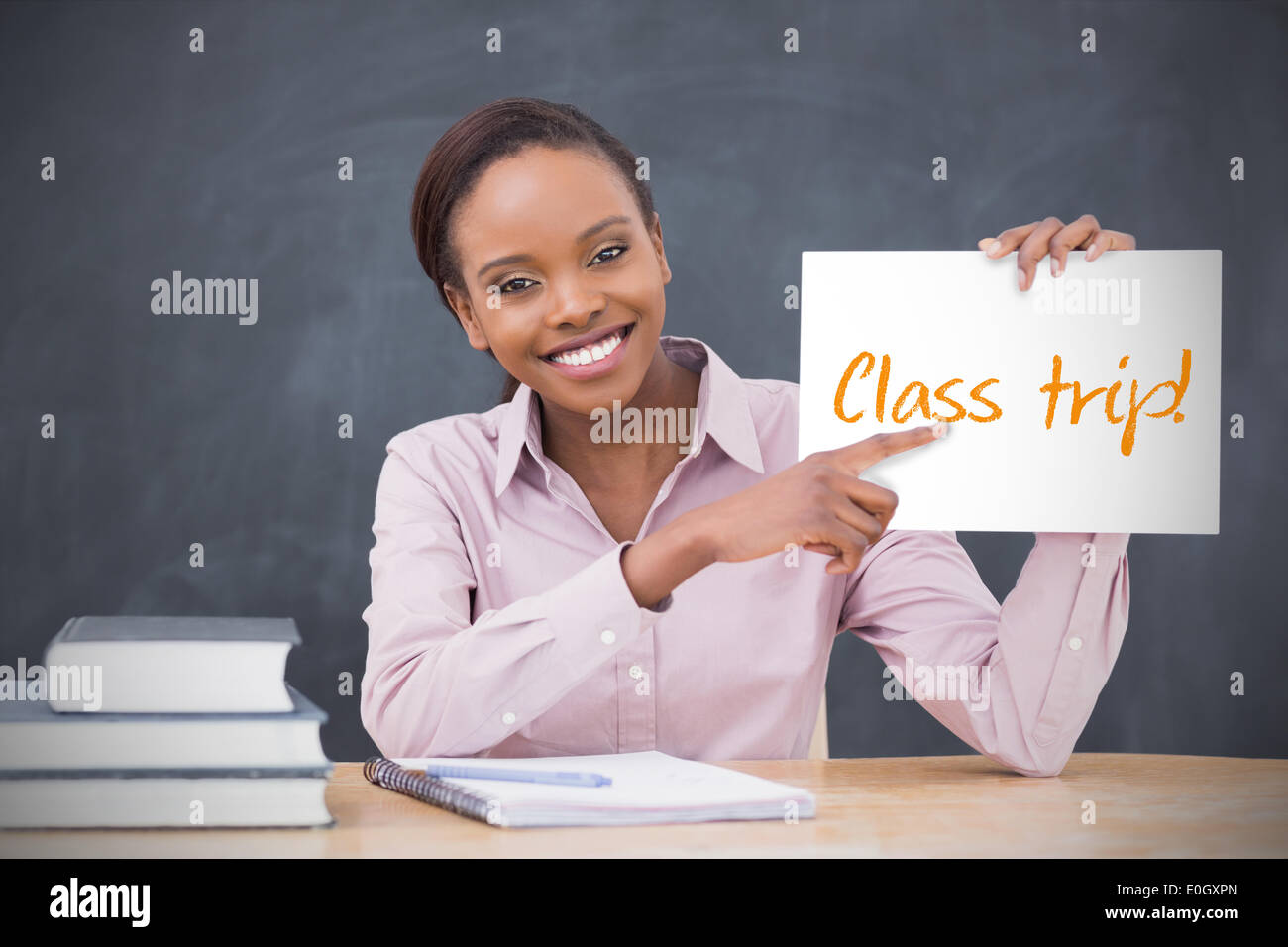 Happy teacher holding page montrant voyage de classe Banque D'Images