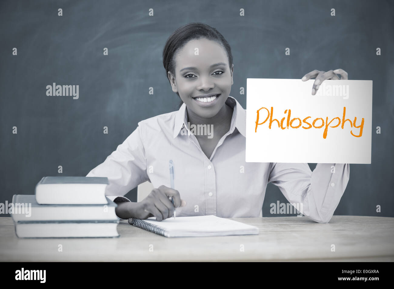 Happy teacher holding page montrant la philosophie Banque D'Images