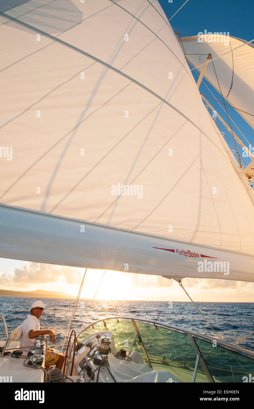 Homme stearing bateau à voile à travers la mer des Caraïbes, des Caraïbes Banque D'Images