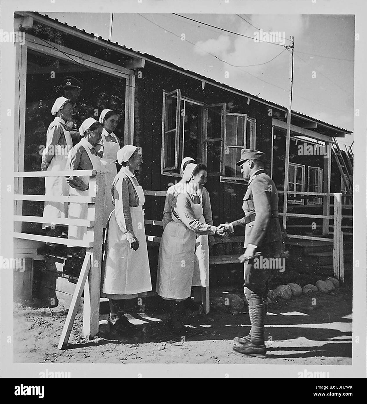 Une photographie montrant une visite à la maison d'un soldat pendant la seconde Guerre mondiale, probablement en Norvège, montrant le personnel militaire interagissant dans un cadre familial pendant la guerre, capturant l'atmosphère civilo-militaire pendant l'occupation nazie. Banque D'Images