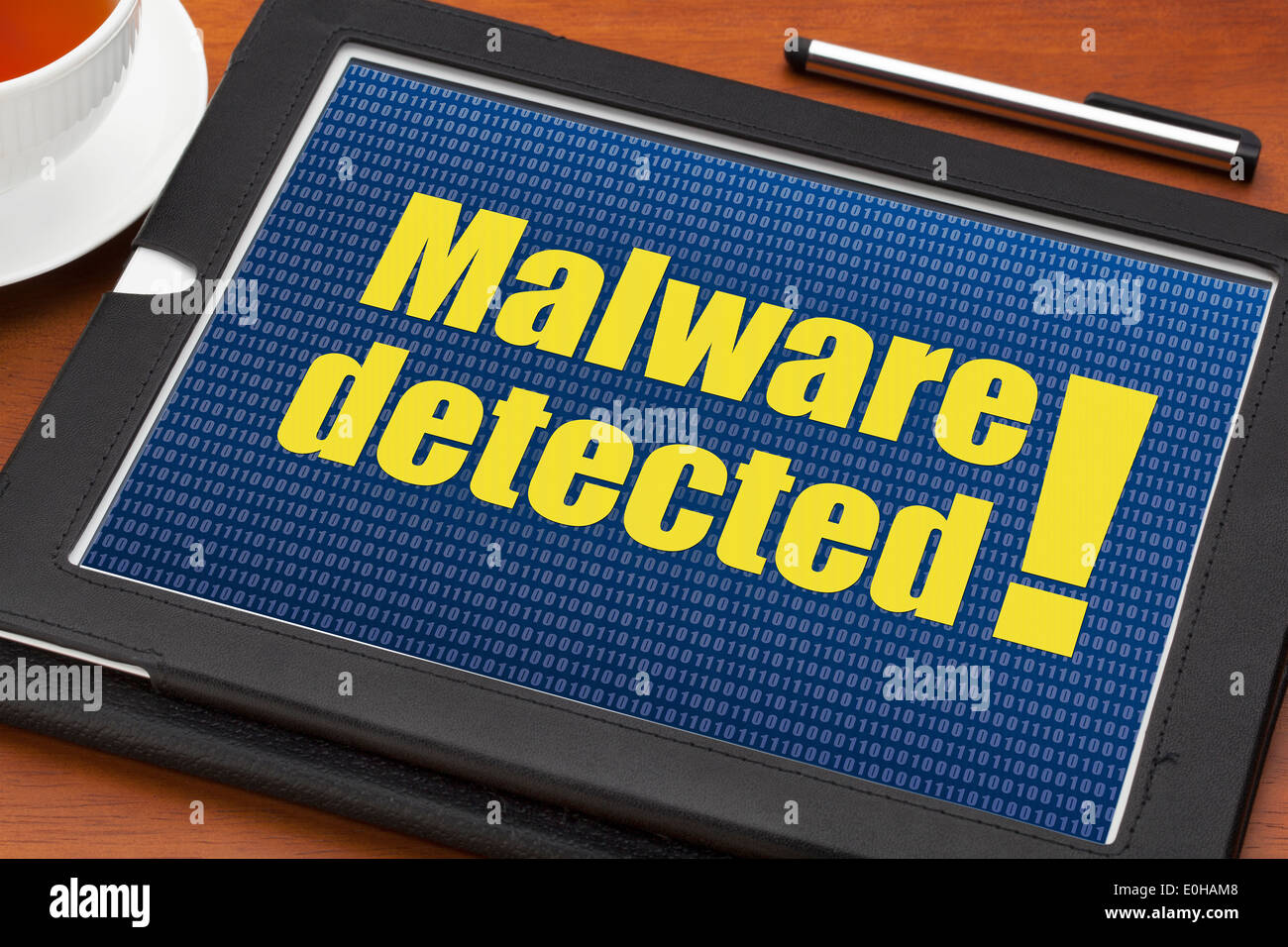 Alerte malware détecté sur une tablette numérique avec une tasse de thé Banque D'Images