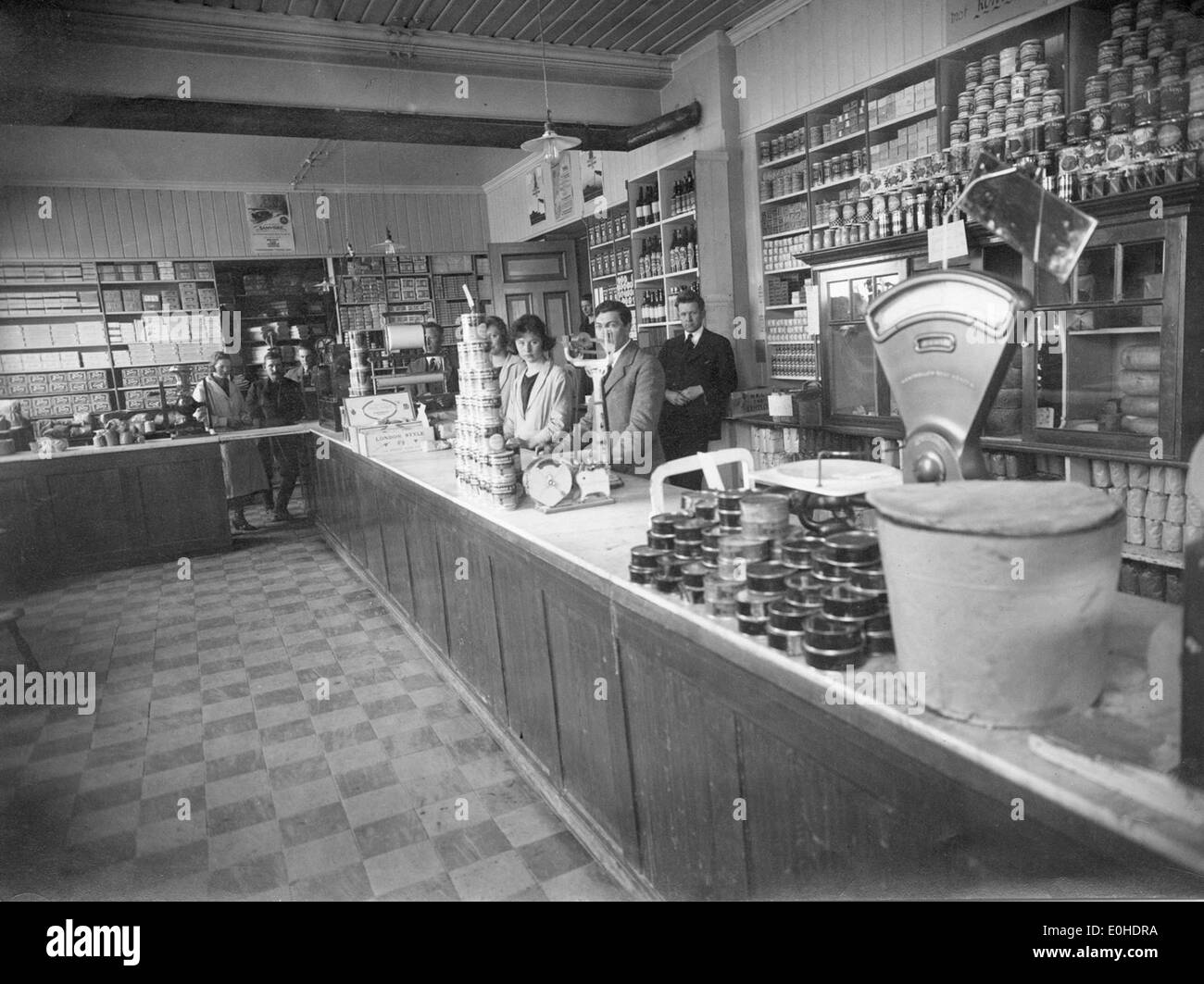Photographie représentant des femmes travaillant derrière le comptoir du Ringerike Samvirkelag, un magasin coopératif en Norvège. L'image capture la vie quotidienne et le rôle des femmes dans la société norvégienne au début du XXe siècle. Banque D'Images Photographie représentant des femmes travaillant derrière le comptoir du Ringerike Samvirkelag, un magasin coopératif en Norvège. L'image capture la vie quotidienne et le rôle des femmes dans la société norvégienne au début du XXe siècle. Banque D'Images