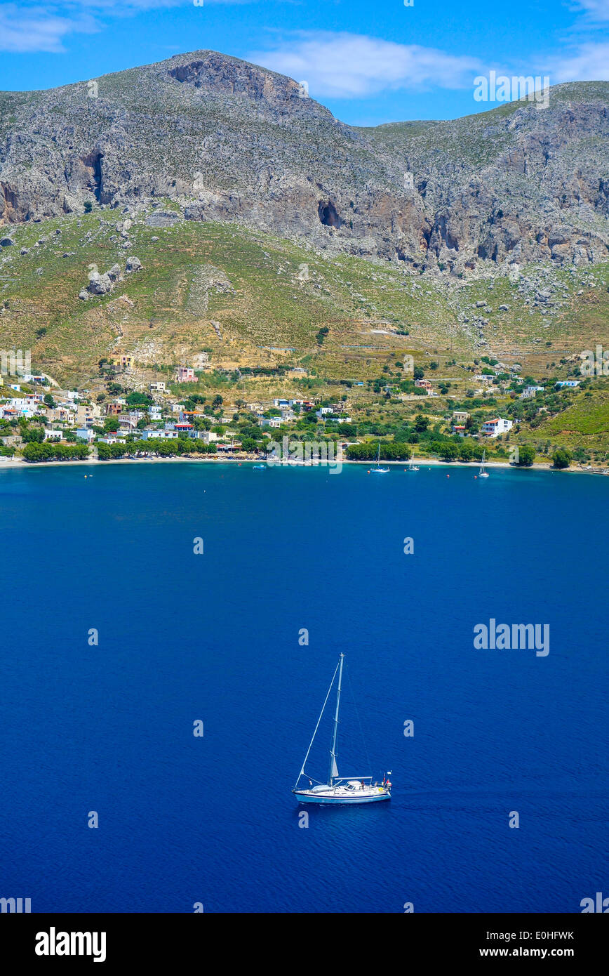 Yacht blanc sur la mer bleue de la baie, avec les collines environnantes, Grèce Banque D'Images