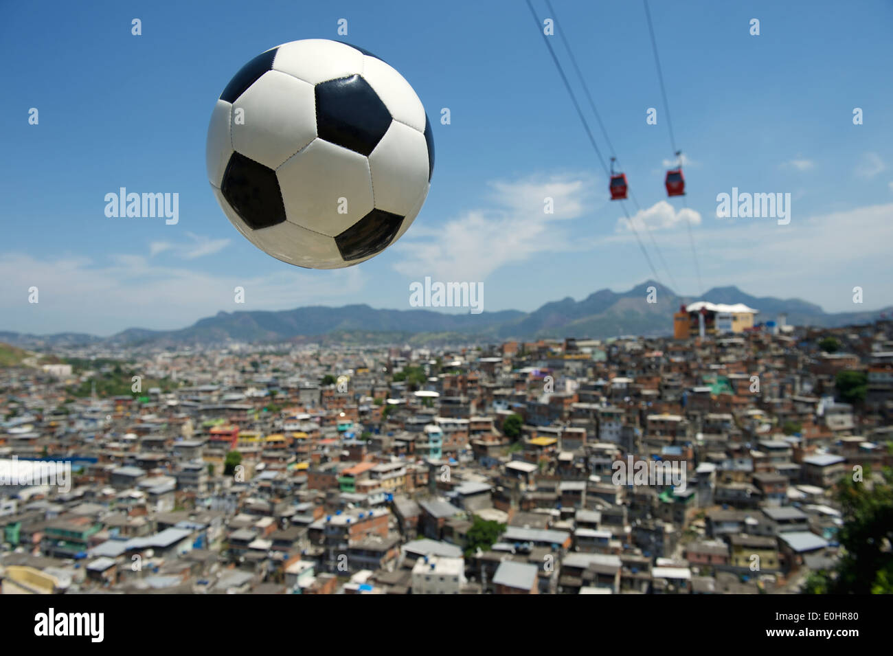 Ballon de soccer Football volant dans le ciel avec des cable cars rouge au-dessus de Rio de Janeiro Brésil favela Complexo do Alemao Banque D'Images