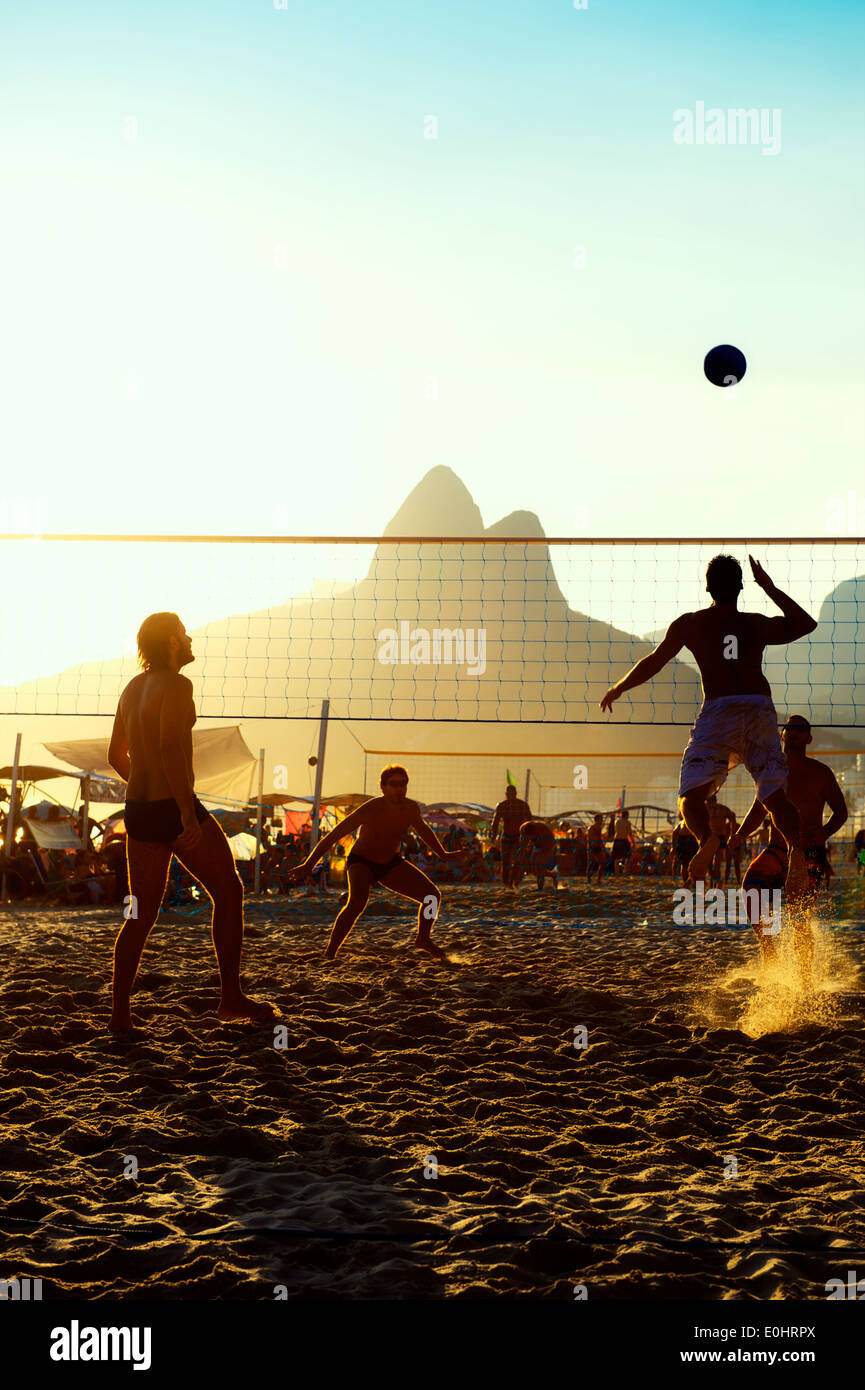 Carioca brésiliens Rio de Janeiro Brésil sunset beach-volley match contre une silhouette de montagne Dois Irmãos Ipanema Beach Banque D'Images