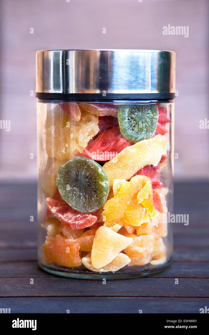 Mélange de fruits sucrées séchées dans un bocal (ananas, kiwi, pamplemousse et fleurs d'hibiscus). Banque D'Images