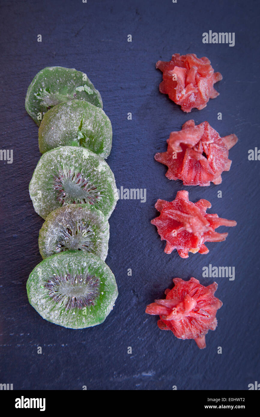 Kiwi sucrées séchées et fleur d'hibiscus sur une plaque en ardoise noire Banque D'Images