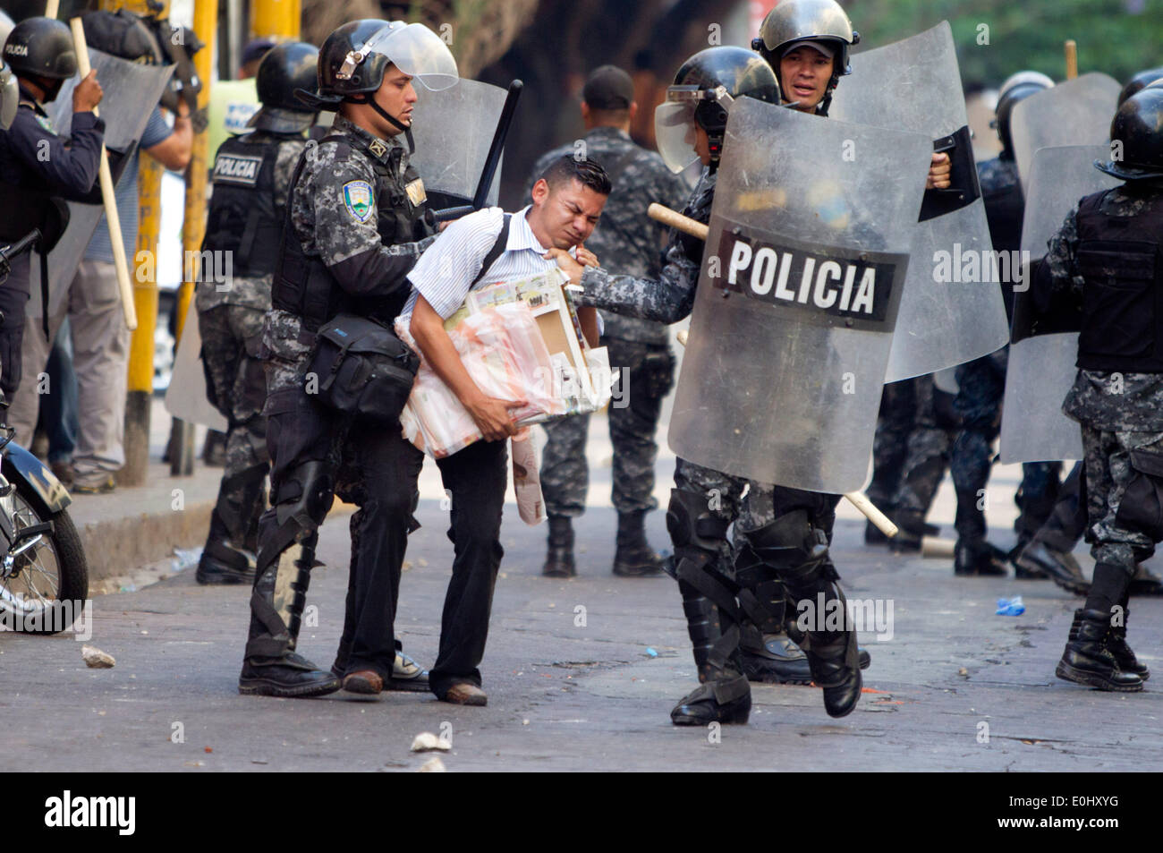 Tegucigalpa, Honduras. 13 mai, 2014. Des éléments de la police de détenir une personne au cours d'un affrontement entre partisans de l'ex-Président du Honduras, Manuel Zelaya, et la police, devant le Congrès national à Tegucigalpa, Honduras, le 13 mai 2014. Partisans et des députés du Parti de la refondation et de la Liberté (Libre, pour son sigle en espagnol), la seconde force politique au Honduras, a éclaté dans le Congrès national le mardi, après des affrontements avec des éléments de la police qui gardait le Palais législatif. Credit : Rafael Ochoa/Xinhua/Alamy Live News Banque D'Images