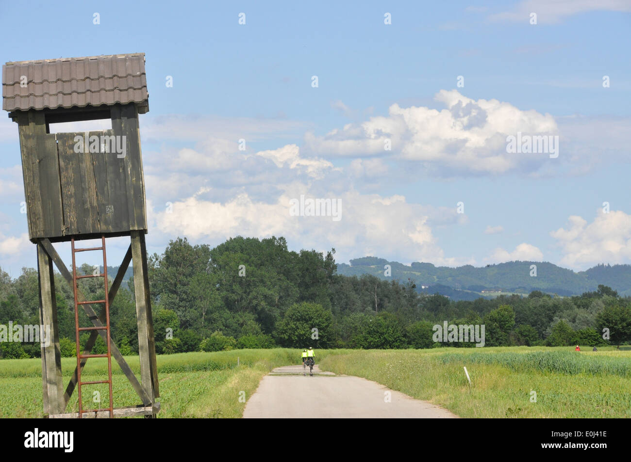 Deux cyclistes équitation leurs vélos passé un repaire d'observation d'oiseaux le long du Danube, entre Mauthausen et Oberösterreich, Autriche Banque D'Images