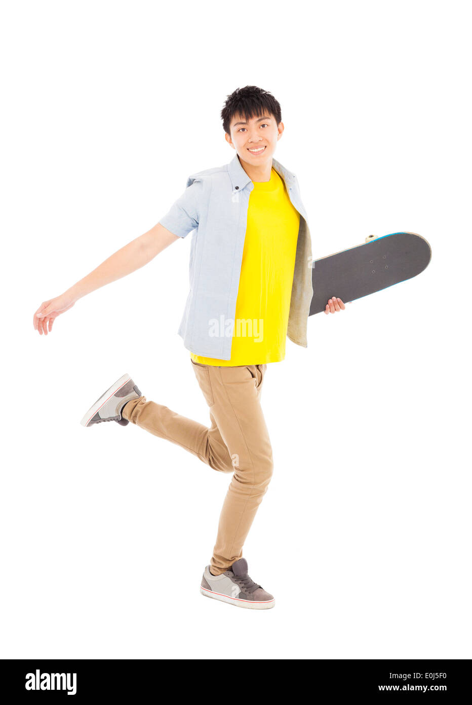 Jeune homme dynamique tenant un skateboard et la marche Banque D'Images
