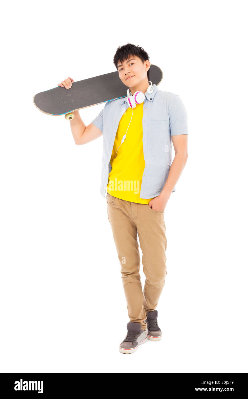 Jeune homme debout et tenant un skateboard Banque D'Images