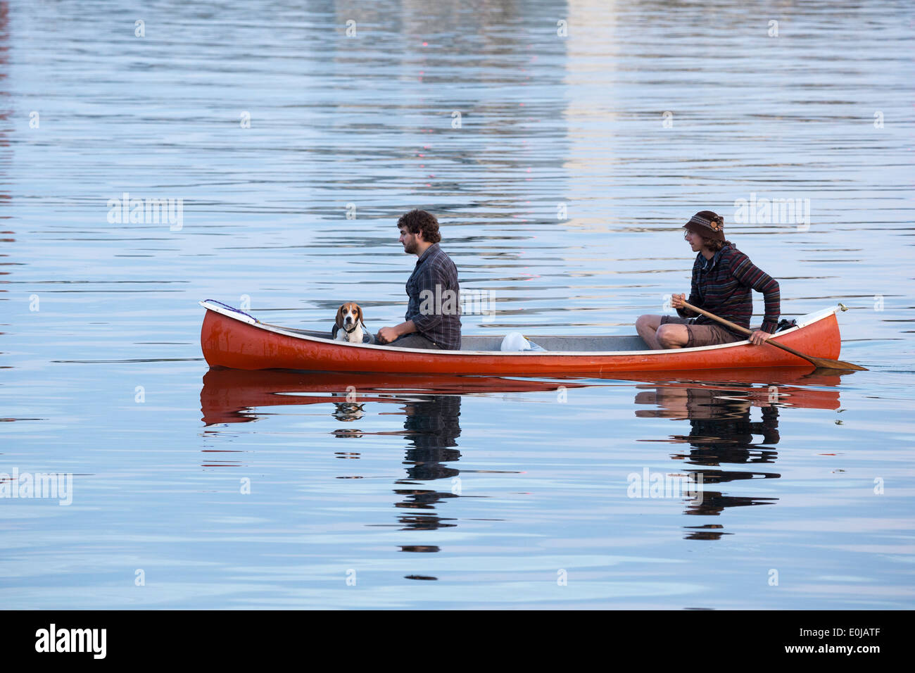 Deux jeunes hommes et le chien en canoë sur le détroit de Juan de Fuca au crépuscule-Victoria, Colombie-Britannique, Canada. Banque D'Images