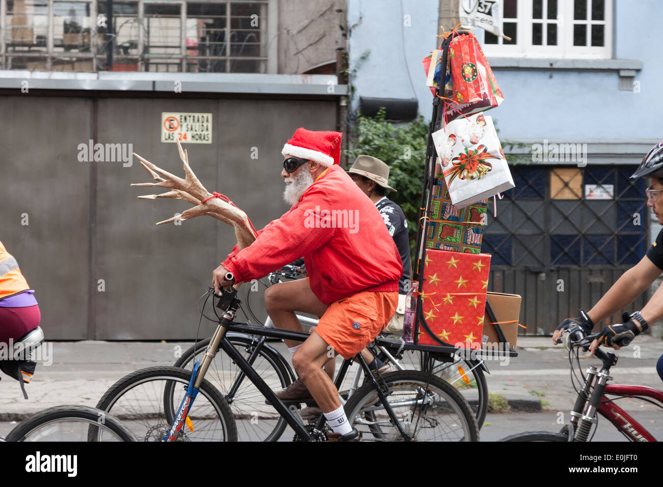 Man riding a bike habillé en père Noël sur le dimanche sans voiture Banque D'Images