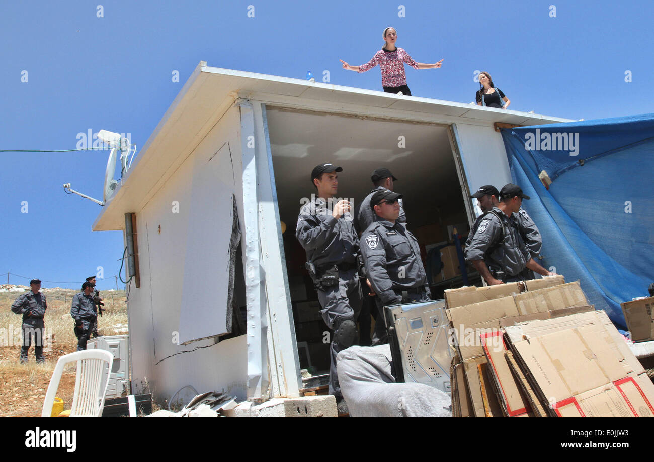 (140515) -- JÉRUSALEM, 15 mai 2014 (Xinhua) -- Les colons se tenir sur le toit de leur immeuble en signe de protestation dans le règlement des Maale-Rechavam au nord d'Hébron, le 14 mai 2014. Les Forces de défense israéliennes (FDI)(avec des soldats des forces de police ont démantelé huit constructions illégales dans le règlement des Maale-Rechavam au nord d'Hébron, le mercredi. Le gouvernement israélien a déclaré ces bâtiments en Cisjordanie qui sont construites sur des terres appartenant à des Palestiniens comme illégales et doivent être pris vers le bas. Les colons ont résisté avec des barricades et brûlé des pneus à l'entrée de l'établissement que l'armée fait leur chemin Banque D'Images