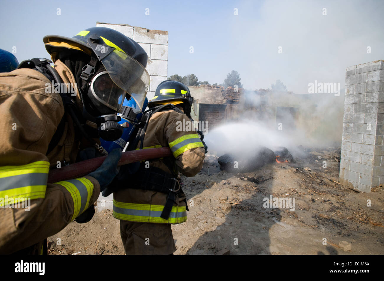 Kaboul, Afghanistan - Membres du Corps de l'air nationale afghane de l'unité de protection incendie répondre un feu intentionnellement le dans un dilapi Banque D'Images