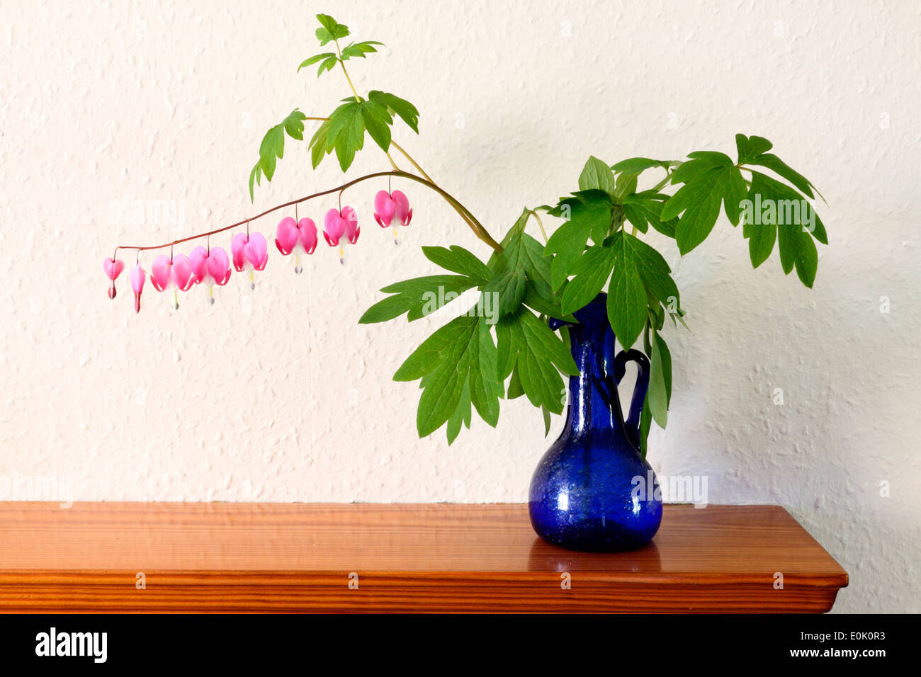 Arrangement de fleurs ornementales de Cœurs et feuillage dans un vase bleu. Banque D'Images