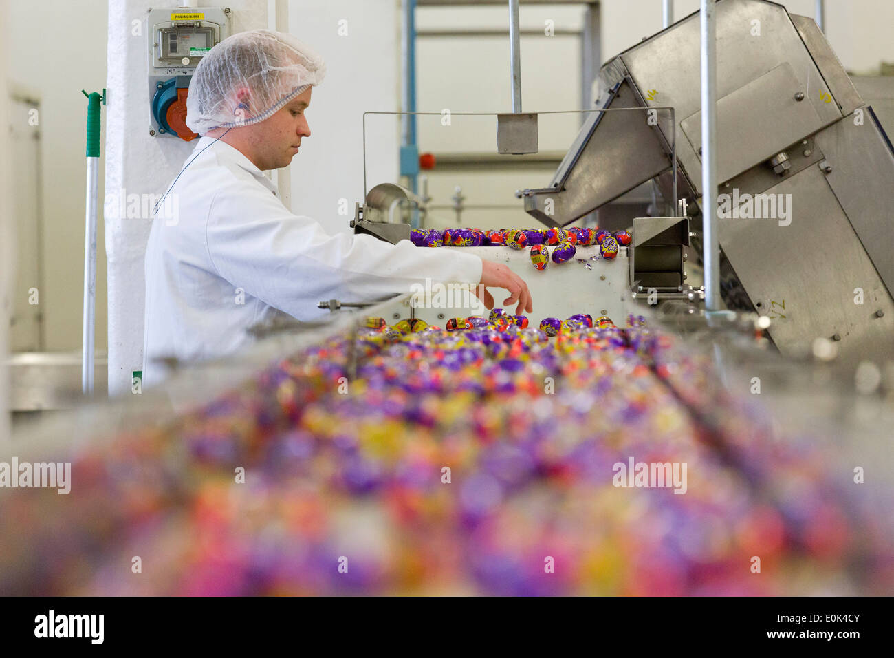 UK, Bournville, Birmingham : un travailleur sur la ligne de production d'oeufs Crème Cadbury. Banque D'Images