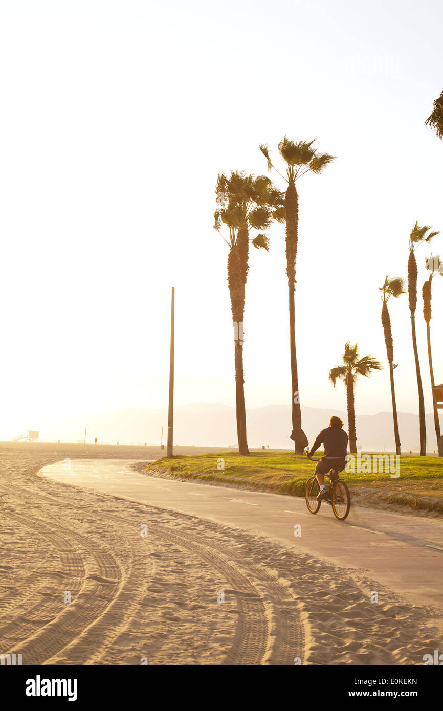 Un homme vers le bas des vélos de la piste cyclable à Sunny Venice Beach, en Californie. Banque D'Images