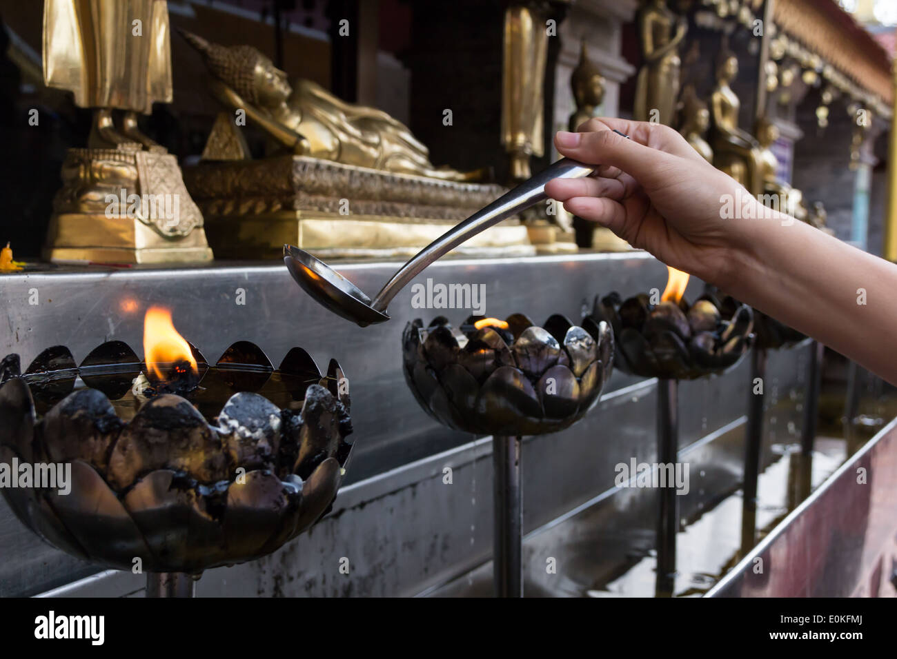 Remplissage d'huile dans un style thaï metal bougie dans temple thaïlandais, Chiang Mai, Thaïlande Banque D'Images