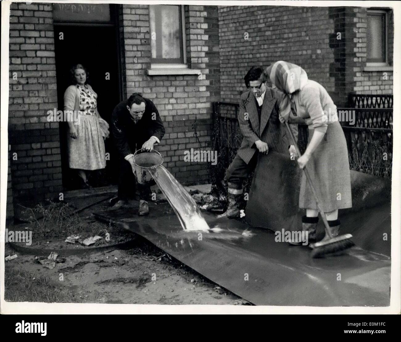 10 févr. 01, 1953 - Les graves inondations à King's Lynn. : M. Mme. Eliery, sur la gauche, avec l'assistance de leur fils et belle-fille, Monsieur Albert et Vera Newdick, vu de la boue de nettoyage de leur linoléum - après que l'eau s'était calmée à King's Lynn, Norfolk, aujourd'hui, où le débordement de la rivière de l'exsudat a causé de graves inondations. Banque D'Images