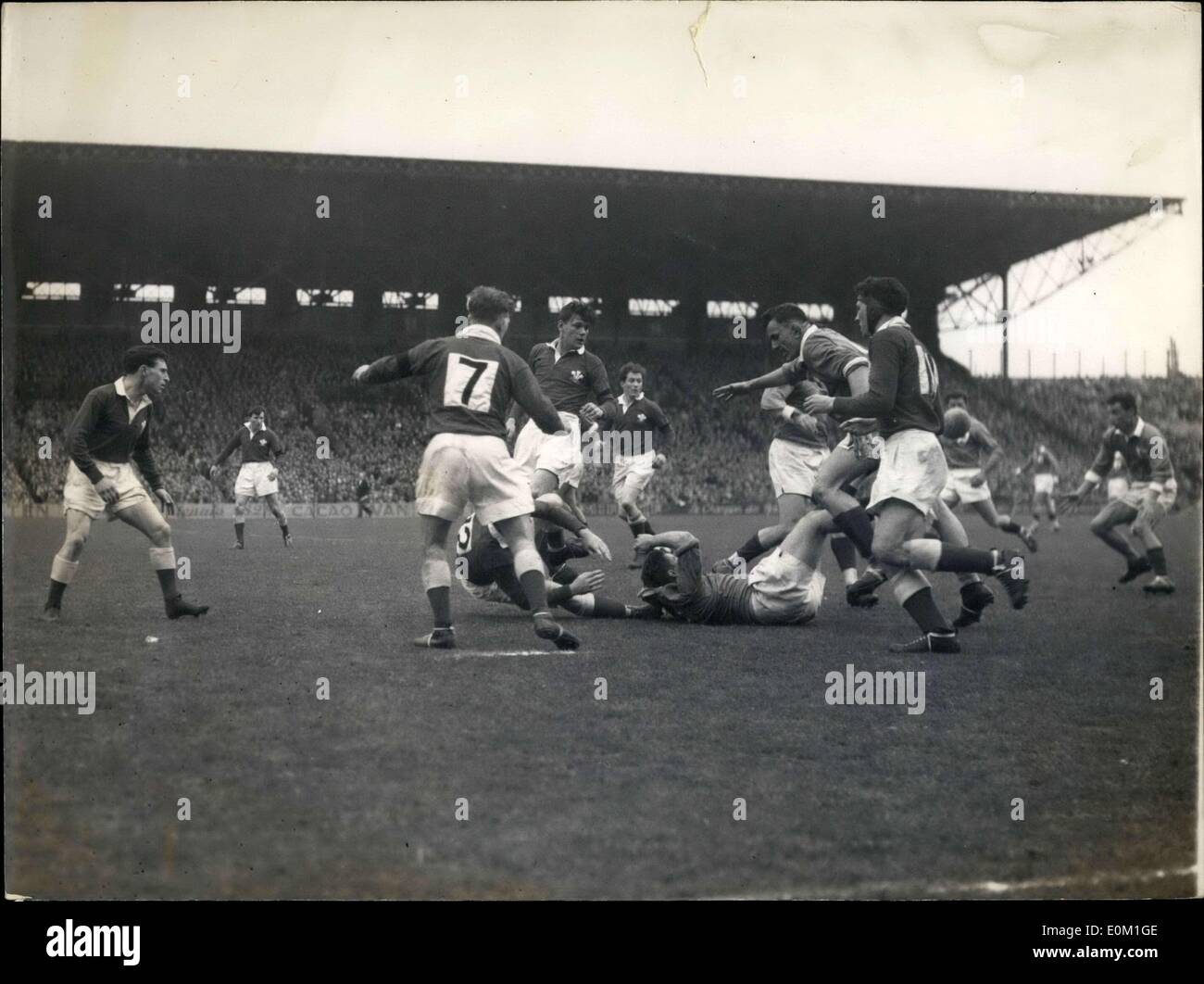 Mar. 28, 1953 - Deux joueurs français sur le terrain sont attaquées avec vigueur par le gallois. À partir de l'arrière, T. Lloyd ; entre ses jambes, Galy, puis Vannier (couché) ; à droite, Dufau qui s'apprête à recevoir le ballon. Banque D'Images