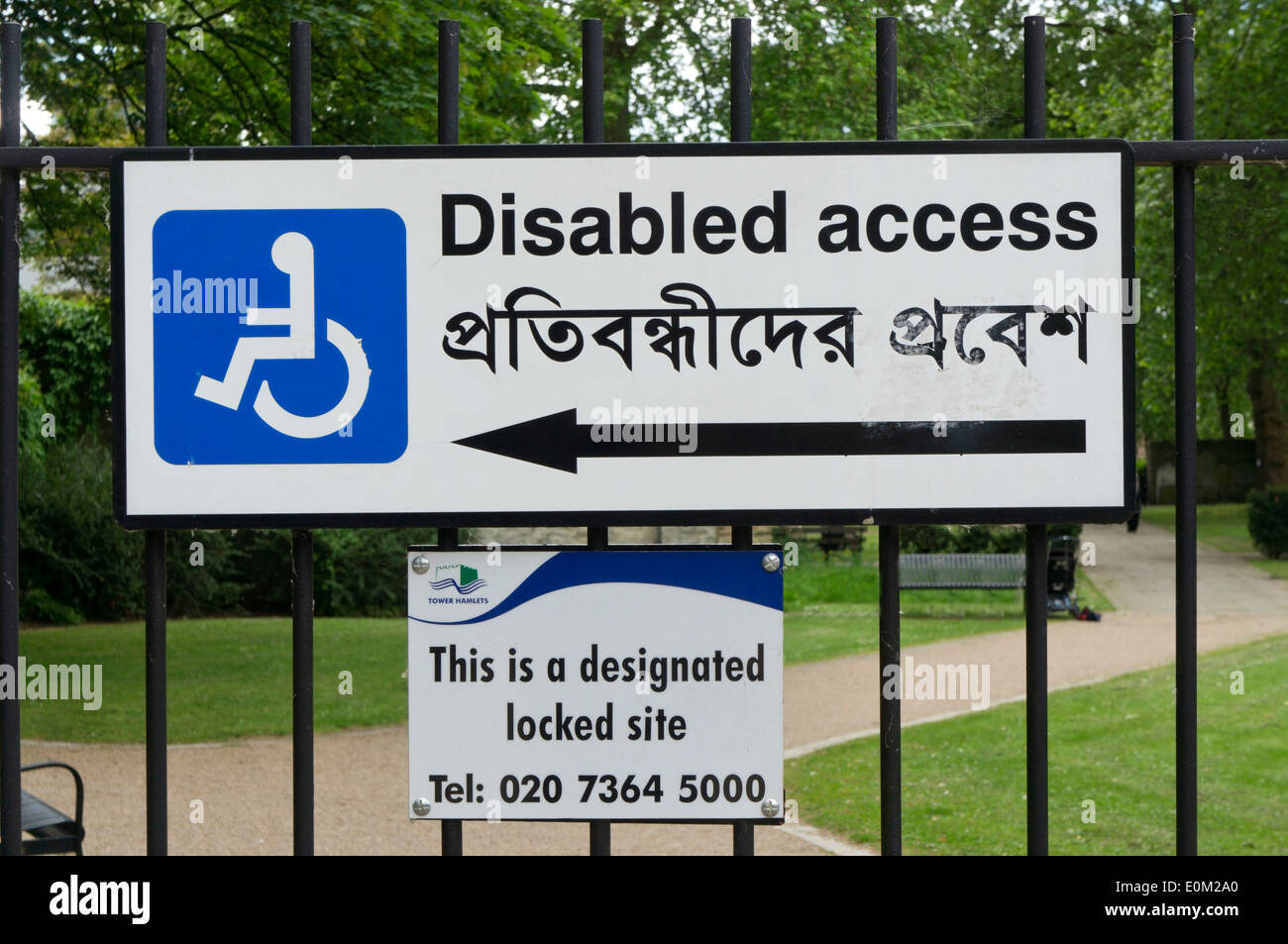 Un accès handicapé signer écrit en anglais et bengali sur les grilles d'un parc Est de Londres. Banque D'Images