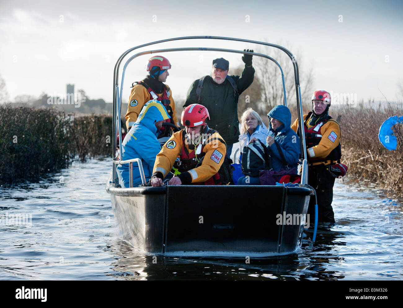 Les inondations sur les Somerset Levels - les résidents de Muchelney approchant Langport sur un bateau monté par un Devon et Somerset Fire Cheminée Banque D'Images