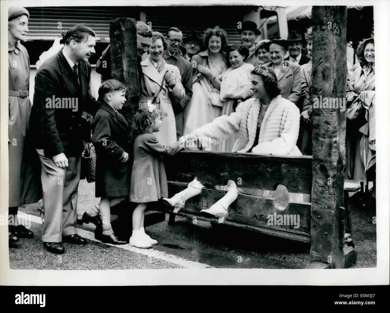 05 mai 1953 - Reprise de la 13e. Siècle juste du Cheam.. le ''Queen'' essaye les stocks... Evan les stocks devaient être vu à la 13ème. Siècle juste qui a été ouvert à la Park Road, Cheam, Surrey, ce matin, par Sir Sidney Marshall M.F. pour Sutton et Cheam, suivi par le couronnement de 27 ans Mme Eunice Pitcher de Chem. Photo montre :- Mme Eunice Pitcher la Reine de la foire - essaie l'ancien stocks - vu par son mari et ses deux enfants Belinda (4) et Clive (6) - à la foire ce matin. Banque D'Images