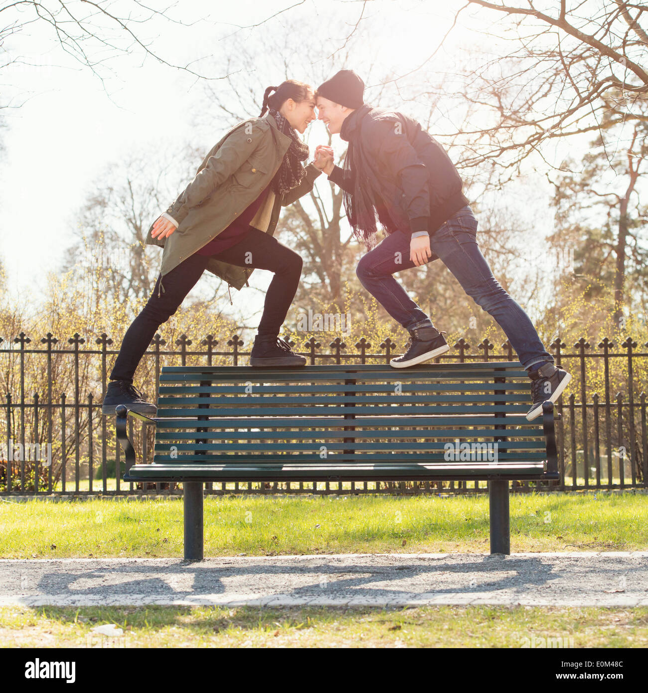 Dating young couple standing on park bench, se tenant la main. Banque D'Images