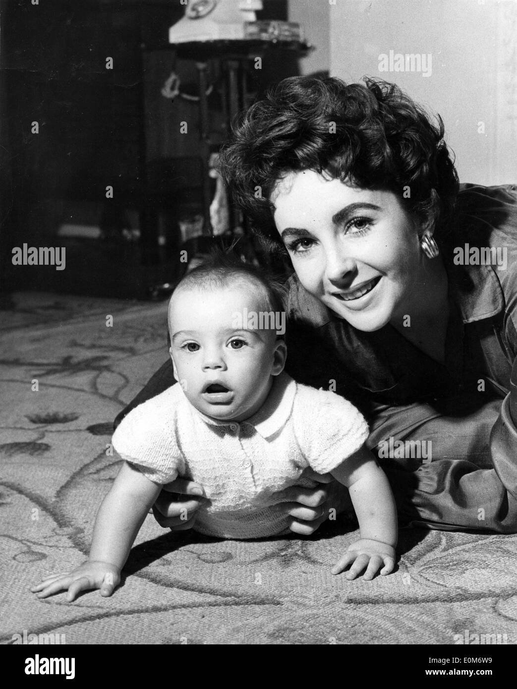 L'actrice Elizabeth Taylor jouant avec son bébé à la maison Banque D'Images