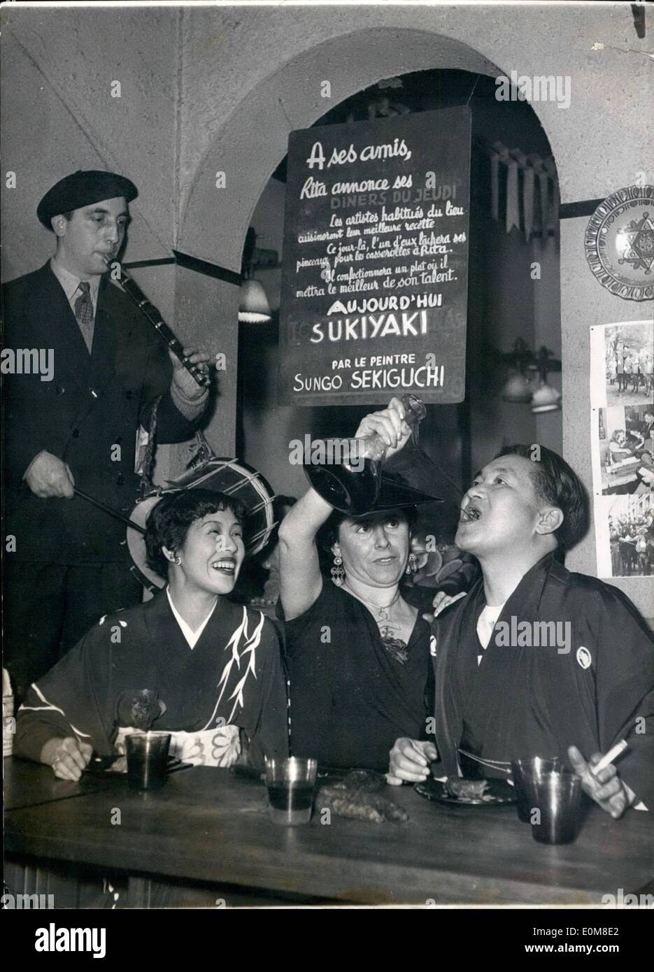 02 février 1954 - Basques et Japonais fraterniser dans un Saint-Germain Des Prés Restaurant : Sukiguishi, un artiste japonais résidant à Paris, des boissons au long cou Basque bouteille vin servi par une fille Basque. Sur la gauche un musicien Basque encourage les invités étrangers. Photo montre le ''Venta'', un restaurant basque dans l'Saint-Des prés Section. Le propriétaire du restaurant vous invite à sa place chaque semaine un peintre résidant dans sa section. C'était au tour du Sekigushi cette semaine. Banque D'Images