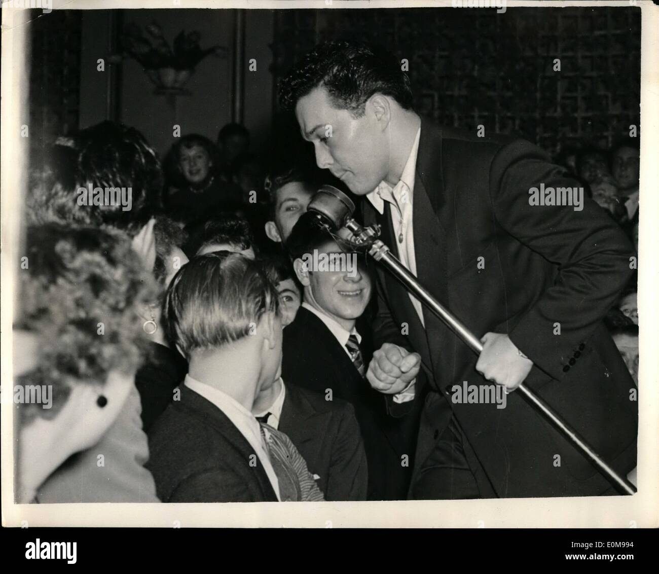 Le 15 février 1954 - 15.2.54 Les adolescents à une session de Swing. Dans la salles de danse, où des sessions de jazz attirent des centaines d'adolescents et le sol est tellement de monde danser devient presque impossible, quelque chose comme l'hystérie peut se développer. Près de 3 000 jeunes à la salle bondée, beaucoup d'entre eux de grimper sur des chaises et tables pour apercevoir leurs idoles de la chanson et de la musique chaude lorsque leader du groupe Ted Heath avec des chanteurs Dickie Valentine et Lita Roza exécutaient. Photo Keystone montre : Dickie Valentine, ex-garçon, appel de théâtre qui est les adolescents top favori, arrache sa cravate pour ce numéro. Banque D'Images