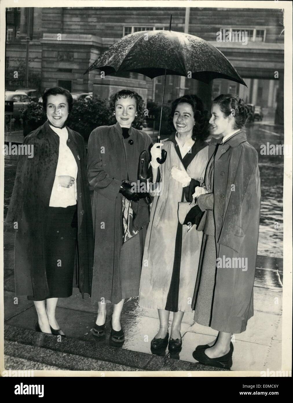 08 août 1954 - Les étudiants français au County Hall : Une partie d'environ 60 étudiants français qui sont dans ce pays pour un mois d'été sur un cours de langues officielles organisées par la Cité Universitaire Club, a visité aujourd'hui le County Hall, où ils ont entendu un exposé sur les travaux de l'L.C.C. et vu le film ''du conseil du comté de Capital'', après quoi ils ont visité le County Hall. Photo montre quatre des étudiants français à l'abri sous un parapluie à l'arrivée du County Hall aujourd'hui Banque D'Images