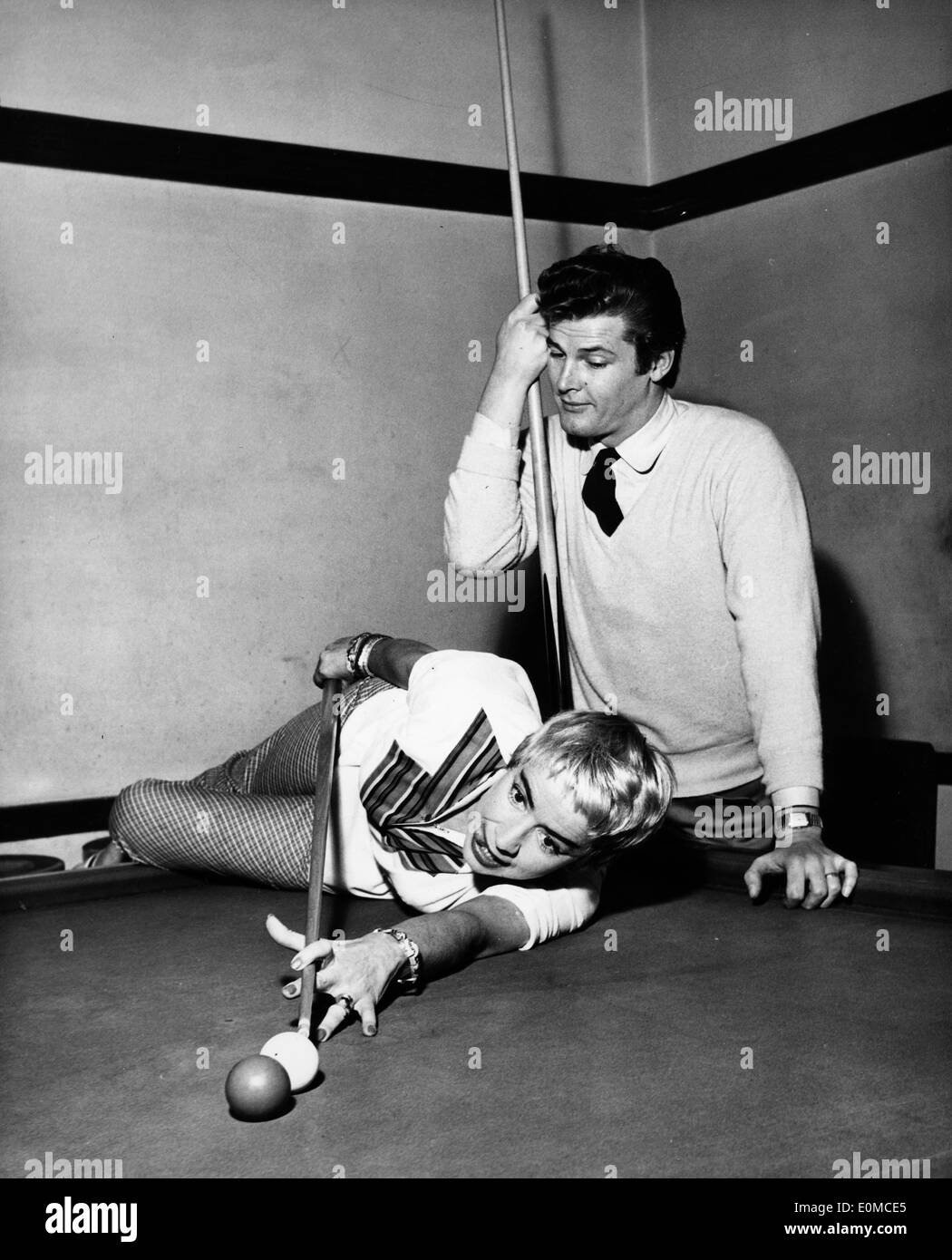 L'acteur Roger Moore et son épouse Dorothy Squires playing pool Banque D'Images