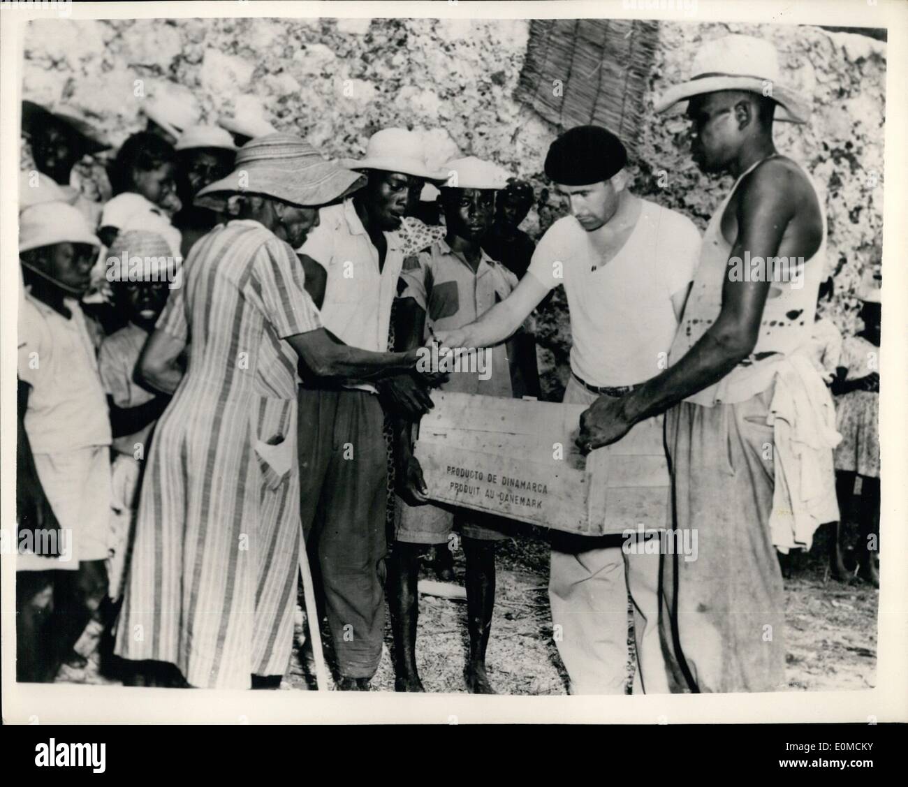 10 octobre 1954 - l'ouragan détruit la ville côtière haïtienne. Des centaines de personnes ont été tuées Le prêtre sort foo : des centaines de personnes ont perdu la vie lorsqu'un Hurrican - avec 115 m.p.h. des vents ont coincé la ville côtière de Hait de Jeremie - récemment. Les maisons ont été emportés dans la mer - l'épave et les décombres ont bloqué les rues et le front de mer pour toute sa longueur était un chamboulement de bateaux et de débris empilés. La photo montre le prêtre de l'Anse d'Hainault met de la nourriture débarquée de H.M.S. Vidal qui est allé à l'aide des victimes. Banque D'Images