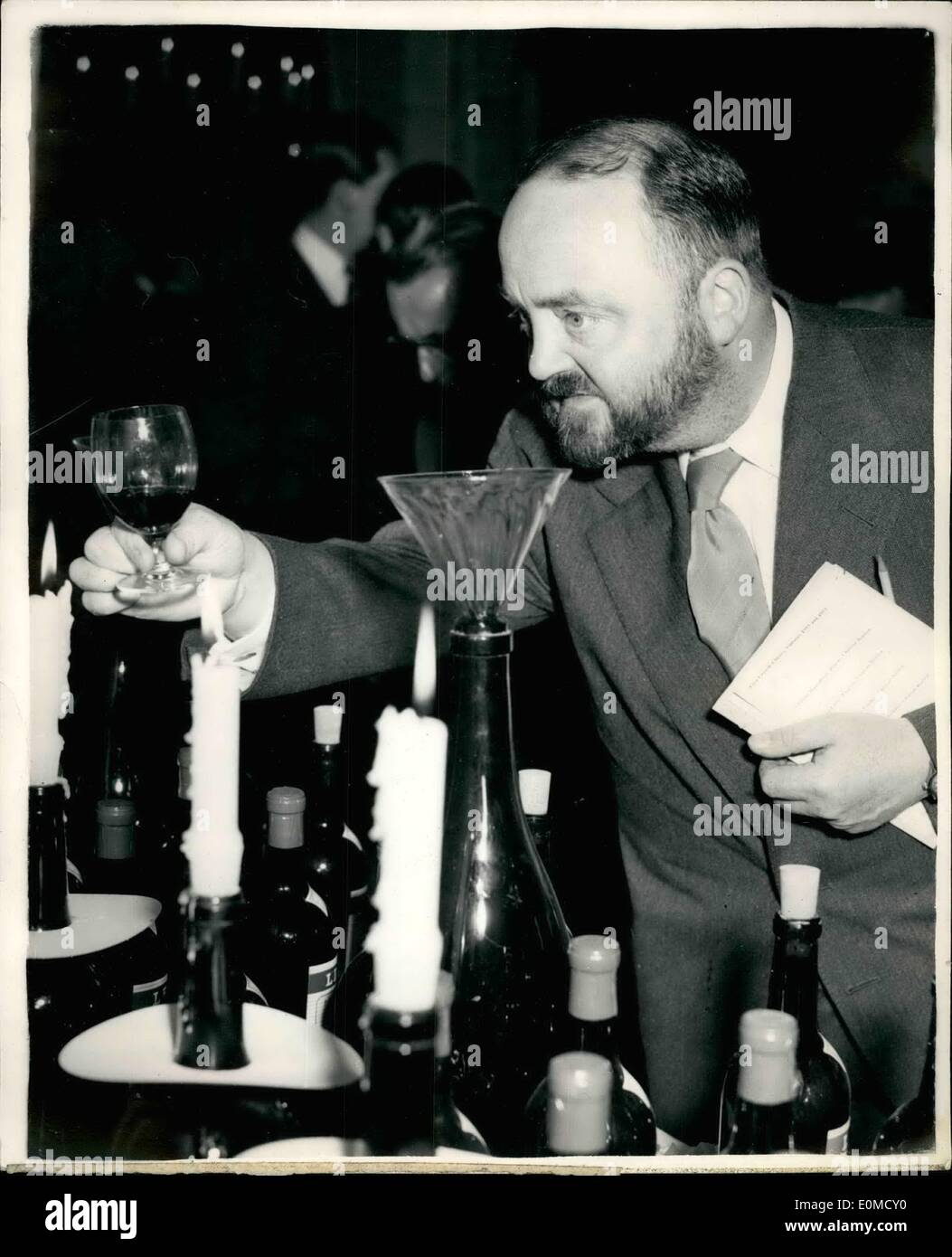 10 octobre 1954 - dégustation annuelle de vins français. Photo montre Philip Harben, le téléviseur sock, études le vin par la lumière des bougies au cours de la cérémonie qui a eu lieu de dégustation de vin dans les caves de Lebegue & Co. Banque D'Images