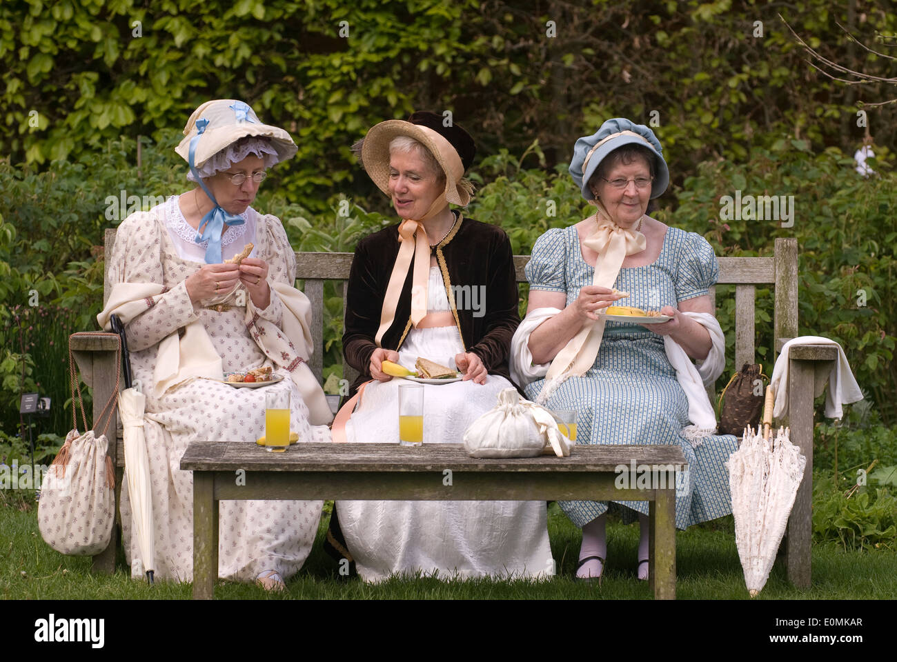 3 femmes en tenue costume Régence dans le jardin de maison de Jane Austen à Chawton, près de Alton, Hampshire, Royaume-Uni. Banque D'Images