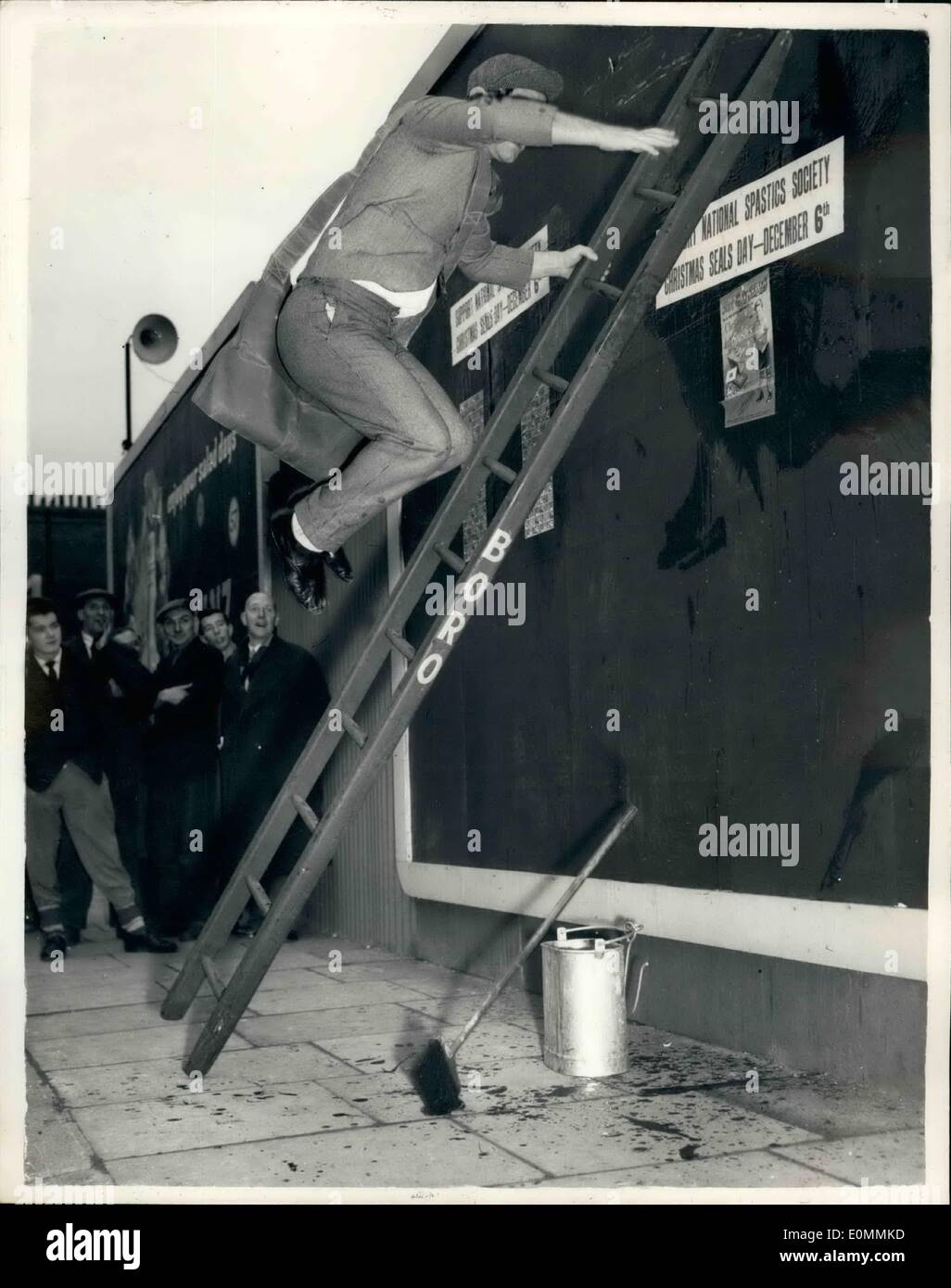 Le 12 décembre 1955 - Norman sagesse lance spastics mer 24. Tous dans la cause de la charité : comédien populaire sagesse normande ce matin lancé London's Spastics jour joints quand il a exécuté son fameux projet de loi Loi sur l'affichage par collage de feuilles de timbres de Noël sur une affiche dans le panneau publicitaire Blandford Street, W.L. ce matin. Photo montre vers le bas va à l'affichage pendant son Norman - loi de l'aide de la Spastics jour ce matin. Banque D'Images