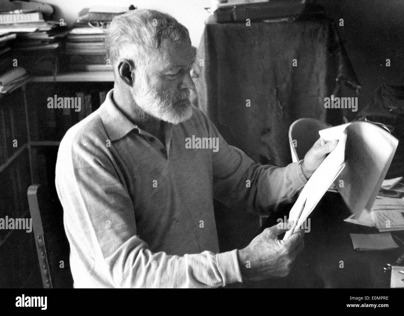 Auteur Ernest Hemingway assis à un bureau de la lecture Banque D'Images