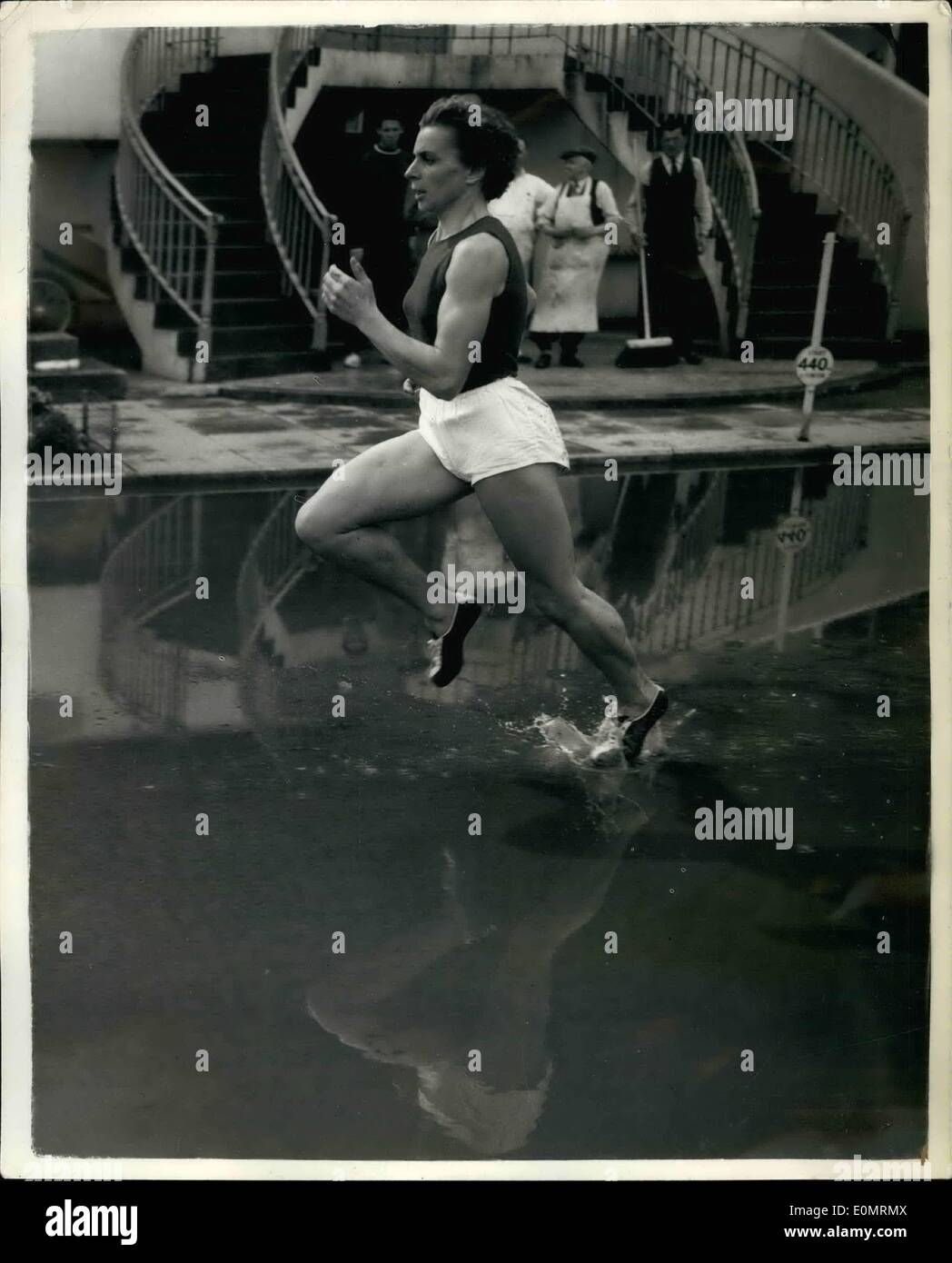 08 août, 1956 - athlètes soviétiques - formation continue en dépit de la pluie à 800 mètres le long d'éclaboussures concurrent : Te sol gorgé d'eau et le train lourd n'a pas empêché le 1/4 soviétique Athlètes de formation à Buenos Aires aujourd'hui - de leur match avec la Grande-Bretagne à White City la semaine prochaine. Phot montre A. Lapshina soviétique le 800 mètres femmes expert - à travers la piste gorgés d'éclaboussures lors de l'entraînement cet après-midi. Banque D'Images