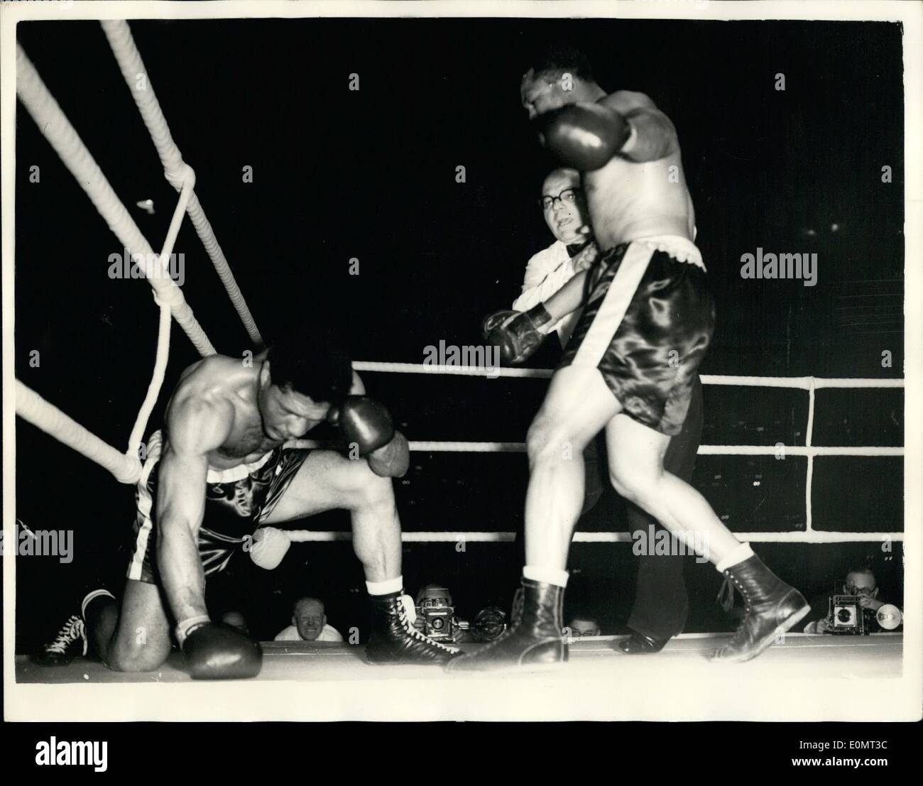 Juin 06, 1956 - Archie Moore conserve son titre contre poids mi Yolande Pompey Harringay à : Archie Moore, la lumière-heavyweight champion du monde, a conservé son titre après qu'il avait défait les Yolande Po Pey dans le dixième tour de leur concours à ce soir. Harringay L'arbitre arrête le concours dans le dixième tour de sauver une autre punition de Pompey. Photo montre Pompey est à genoux dans le dixième tour comme Archie Moore se tient sur lui. Banque D'Images