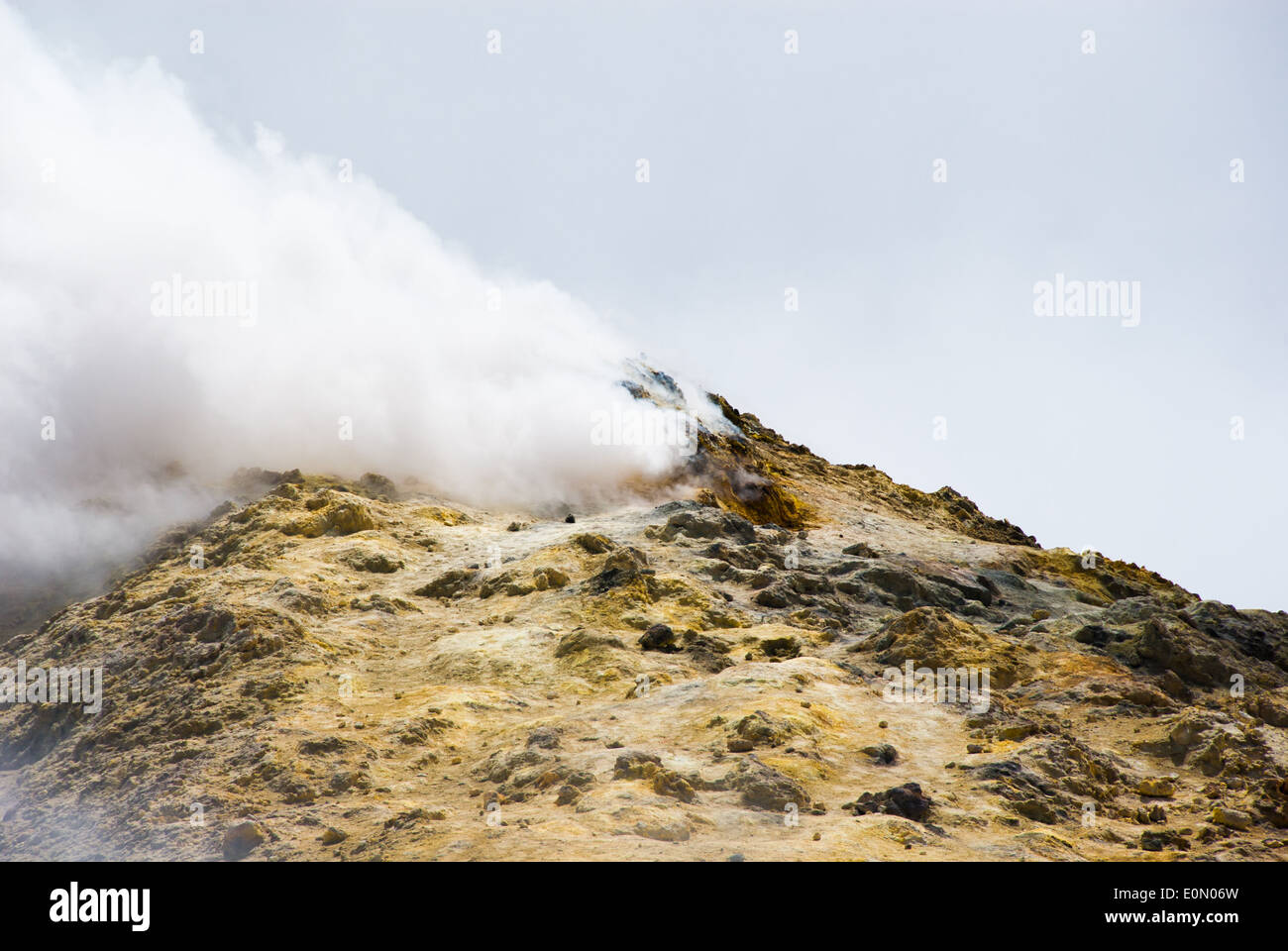 Sur le sommet de l'etna la roche est couverte de soufre et est devenu jaune, nuage de gaz toxique se propager du cratère Banque D'Images
