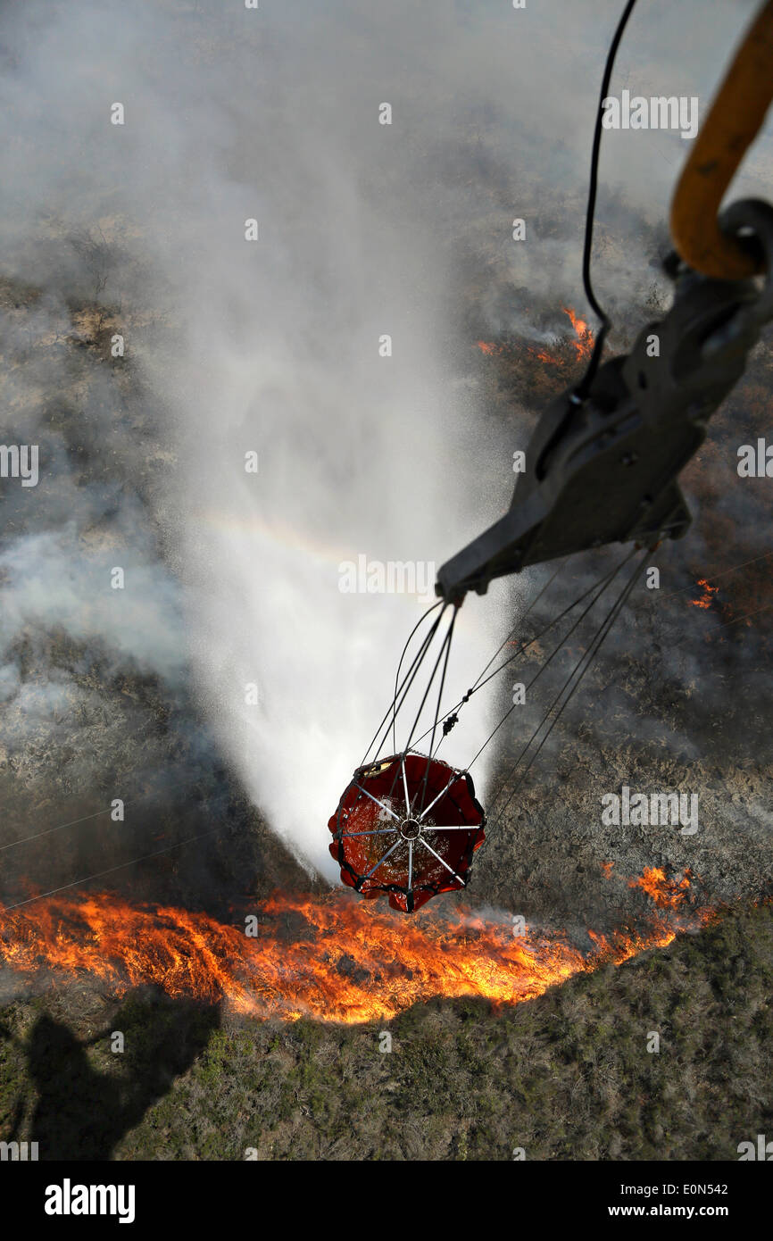 Un US Marine Corps CH-46 Sea Knight helicopter supprime un seau rempli d'eau de la mousson pour aider à lutter contre les incendies de Cocos car elle brûle les contreforts détruire accueil 15 mai 2014, autour de San Marcos, en Californie. Plus de 13 000 évacuations forcées des personnes à leur domicile comme le feu a brûlé dans le comté de San Diego. Banque D'Images