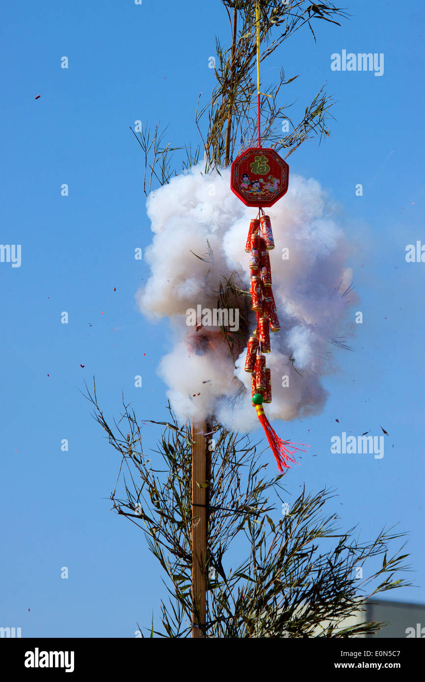 Pétards asiatiques explosant lors d'un festival lunaire vietnamien du nouvel an lié au bambou et pensé pour apporter chance et prospérité Banque D'Images