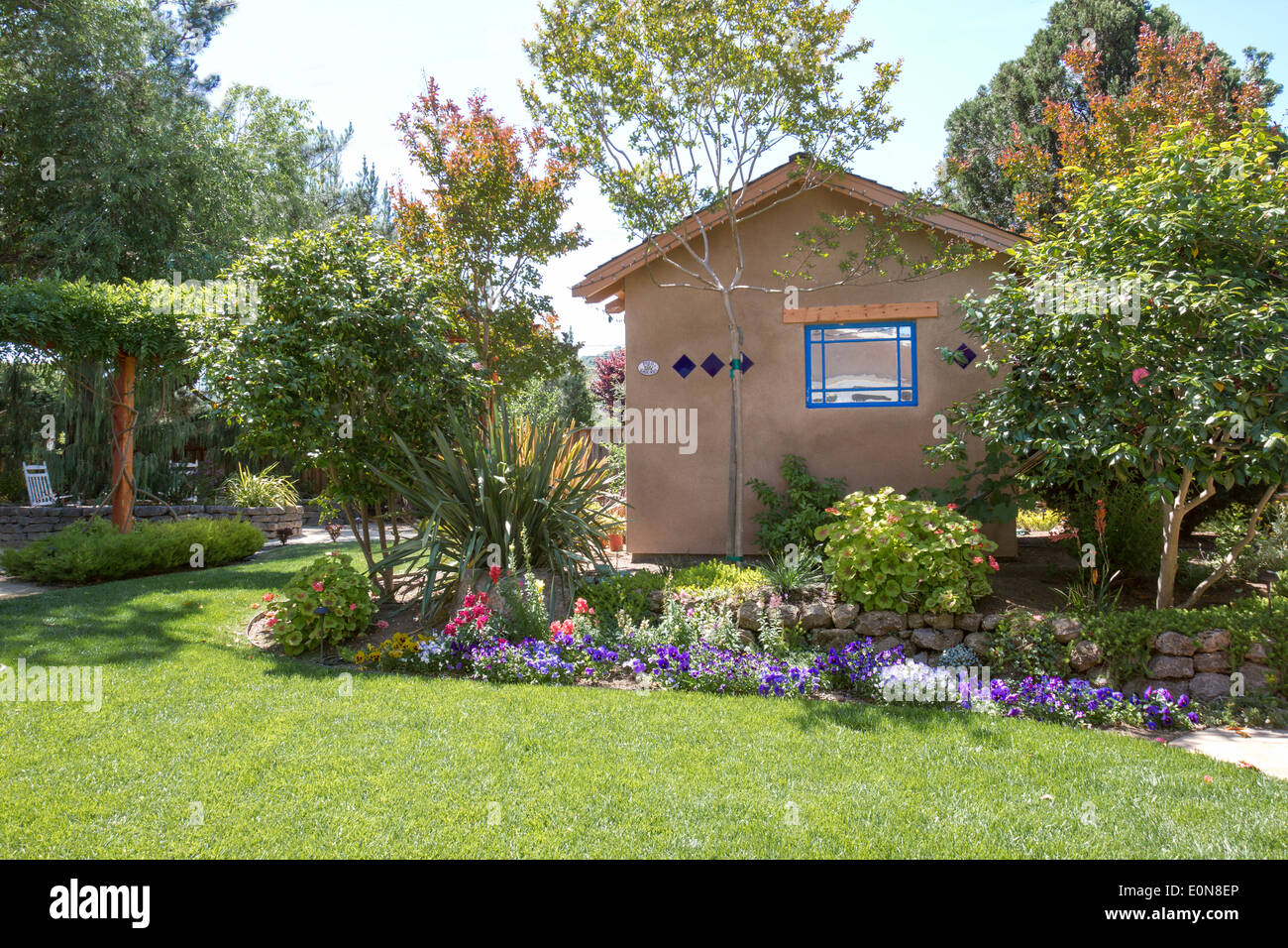 Abri de style sud-ouest dans un beau jardin paysagé jardin avec des fleurs et une végétation luxuriante Banque D'Images
