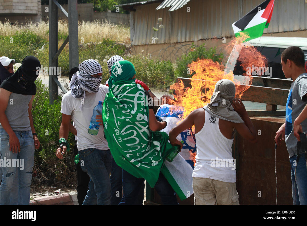 Ramallah, Palestine. 16 mai, 2014. Ramallah, Cisjordanie, territoire palestinien le 16 mai 2014 : Des manifestants palestiniens liting un drapeau israélien lors d'affrontements à l'extérieur de la prison d'Ofer israélienne-run, près de la ville de Ramallah, en Cisjordanie, le 16 mai 2014. un jour après que deux Palestiniens ont été tués par les forces israéliennes au cours d'affrontements à l'extérieur de la prison d'Ofer run-israélienne après une protestation à l'occasion de ''Nakba'' ou ''catastrophe'' de l'état juif de sa création. © Museitef NurPhoto Abdalkarim //ZUMAPRESS.com/Alamy Live News Banque D'Images